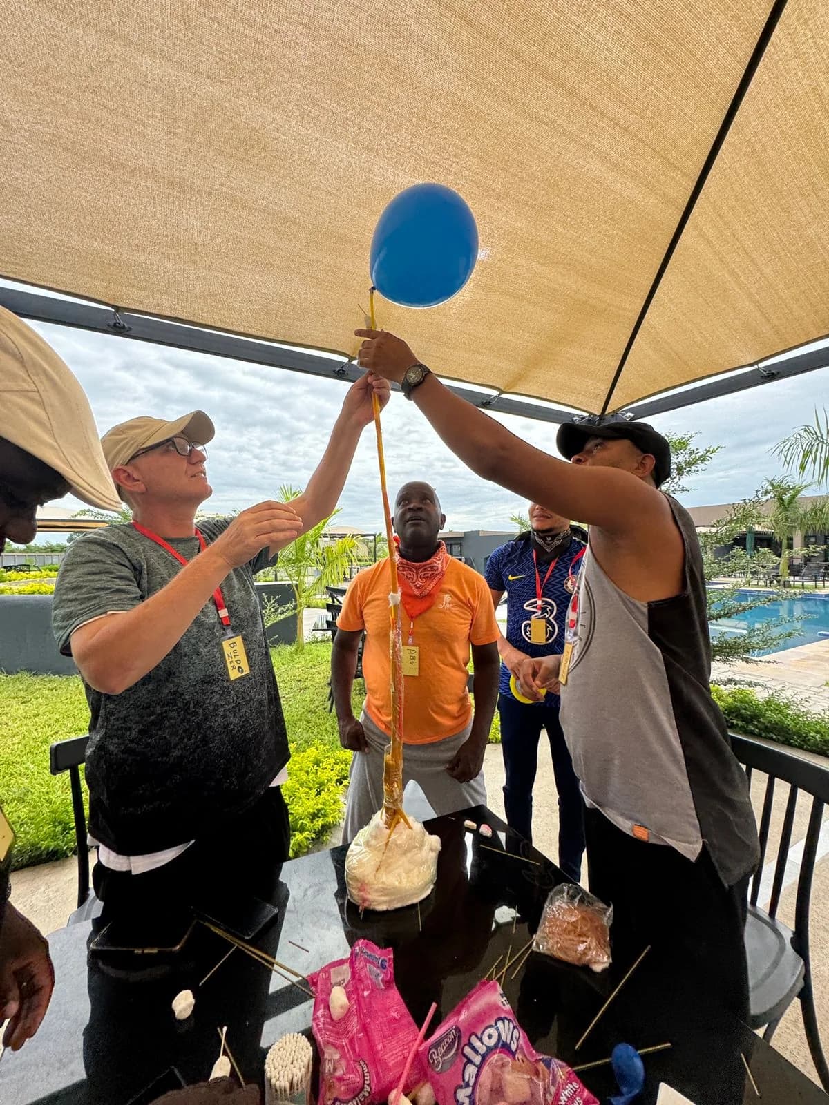 Equipa a erguer um balão, durante um desafio de construção em altura, ao ar livre