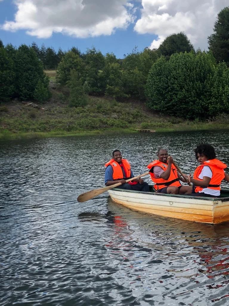 Equipa a remar em conjunto num barco, durante uma atividade de team building ao ar livre